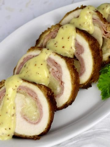 slices of chicken cordon bleu with mustard sauce on top