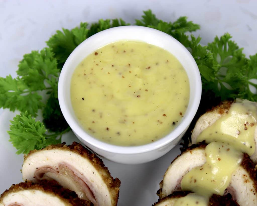 mustard cheese sauce on plate with chicken and parsley