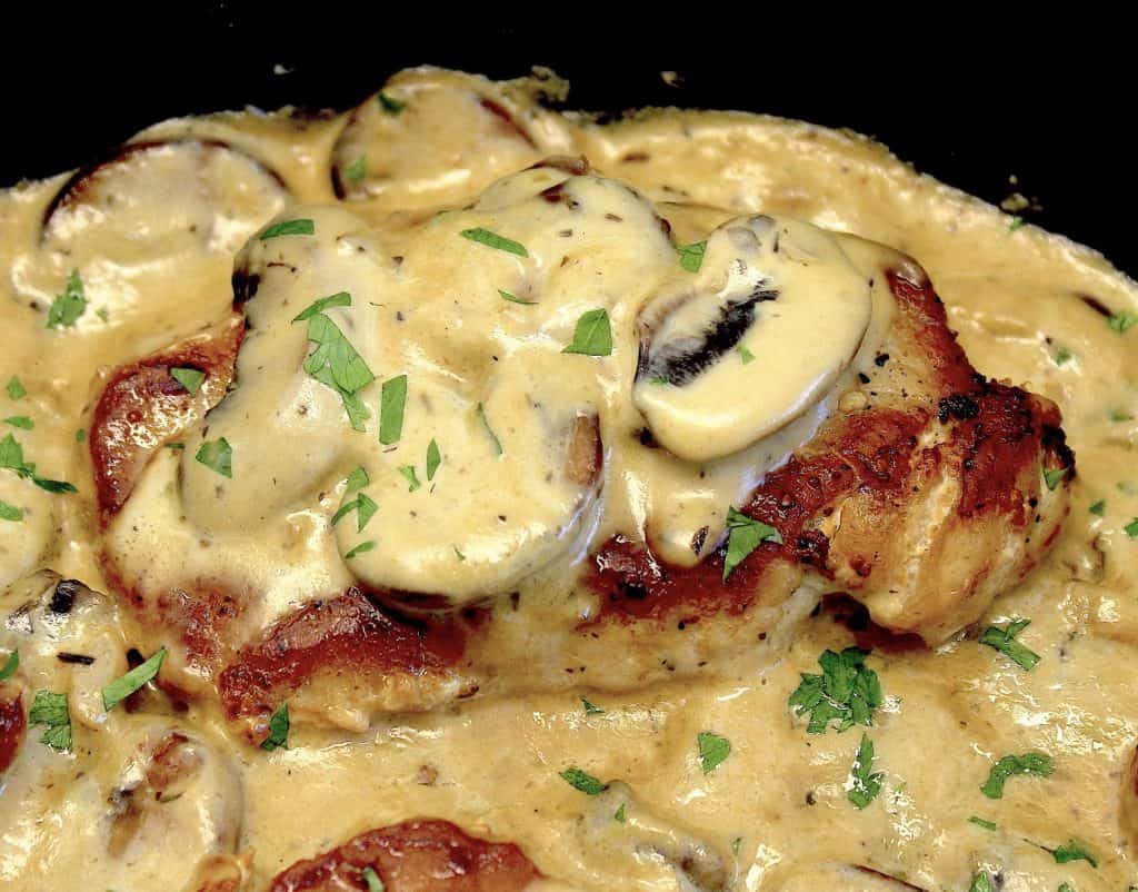 closeup of Smothered Pork Chop with mushroom gravy on top