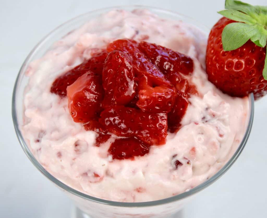 closeup of Strawberries and Cream in glass with chopped strawberries on top