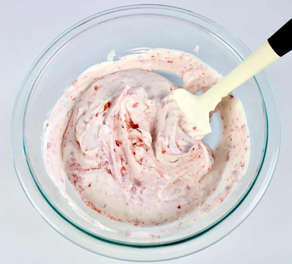 Strawberries and Cream in glass bowl with silicone spatula