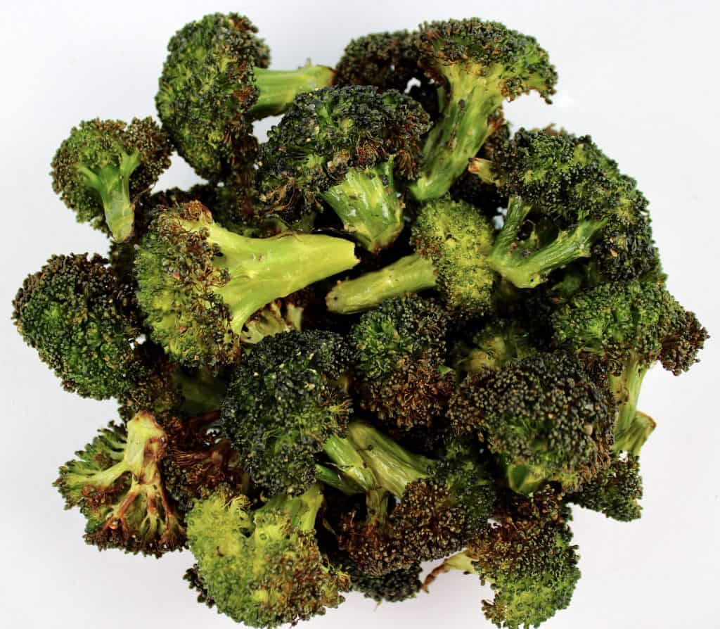 closeup of roasted broccoli in glass bowl