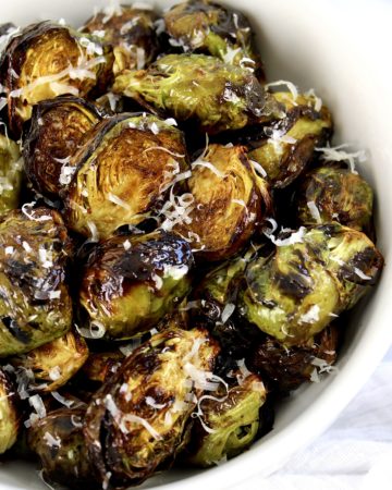 Air Fryer Brussels Sprouts in white bowl with grated cheese on top