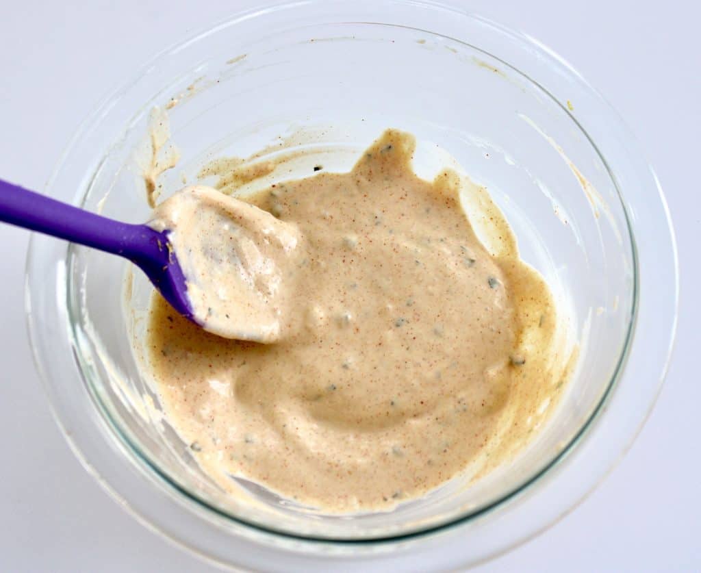 remoulade sauce in glass bowl with purple silicone spoon