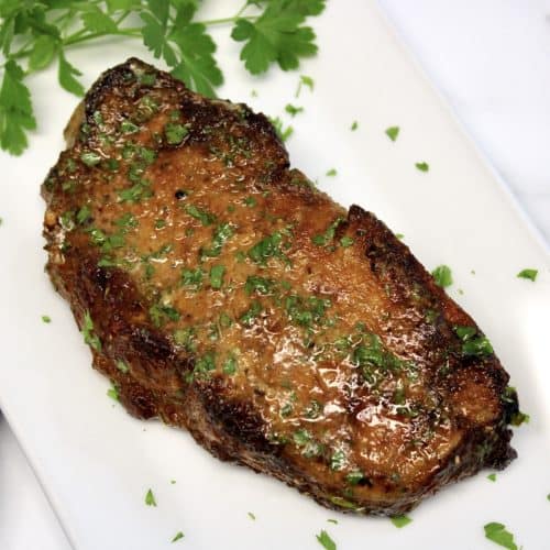 Air Fryer Steak on white plate with parsley