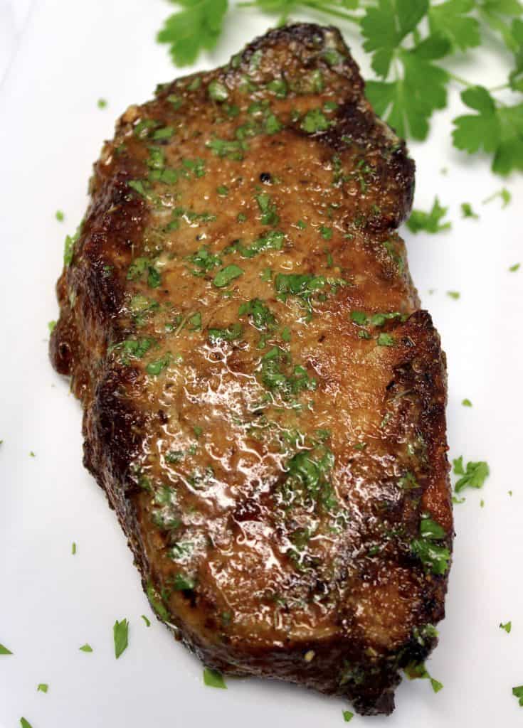 overhead view of Air Fryer Steak on white plate with parsley
