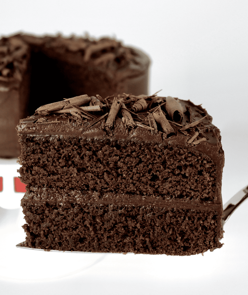 slice of Chocolate Layer Cake being held up with silver cake server