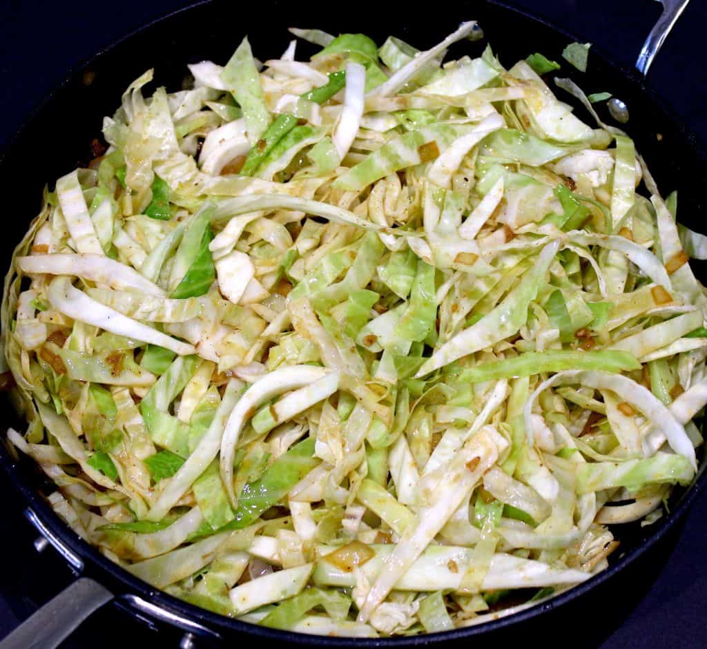 sliced cabbage frying in skillet