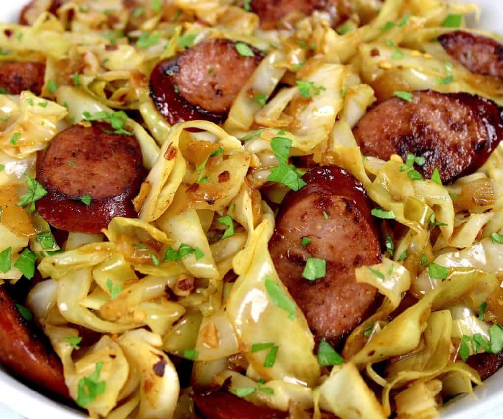 closeup of Fried Cabbage and Sausage with parsley on top