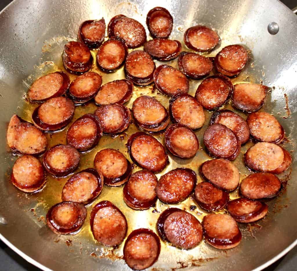 slices of sausage frying in pan