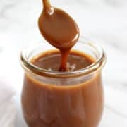 caramel sauce being spooned out of jar