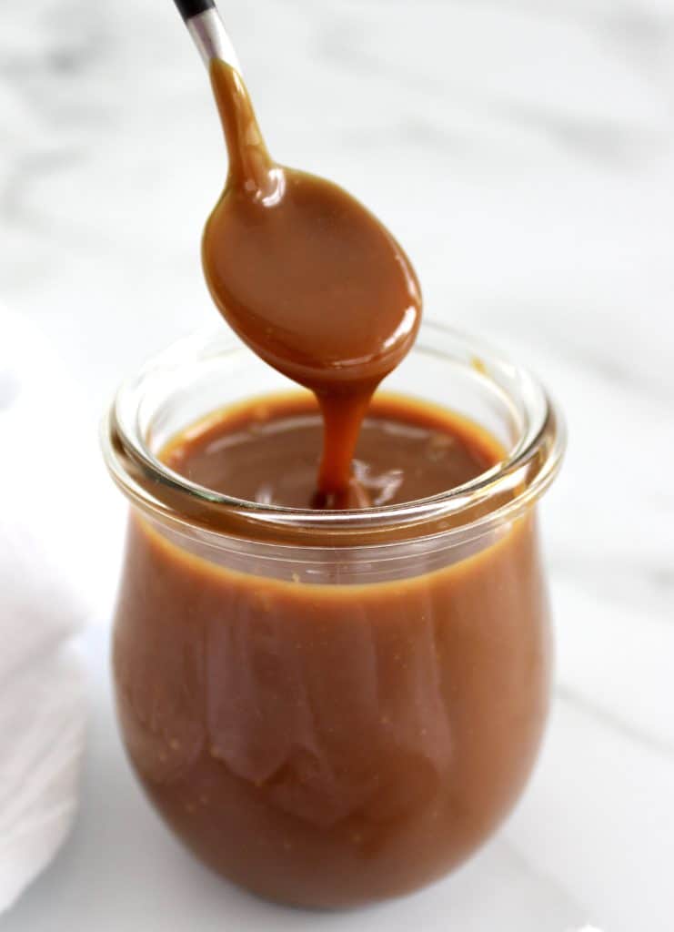 caramel sauce being spooned out of jar