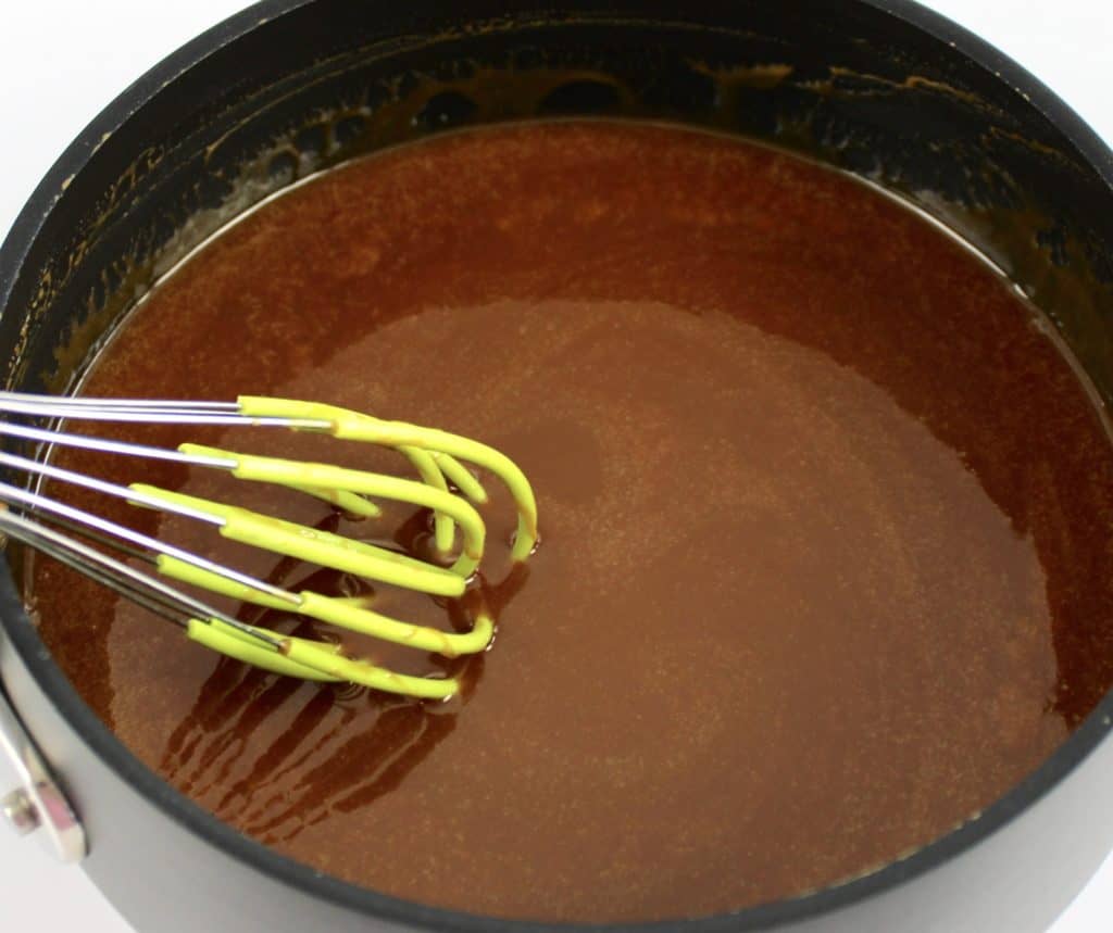 caramel sauce in saucepan with silicone whisk