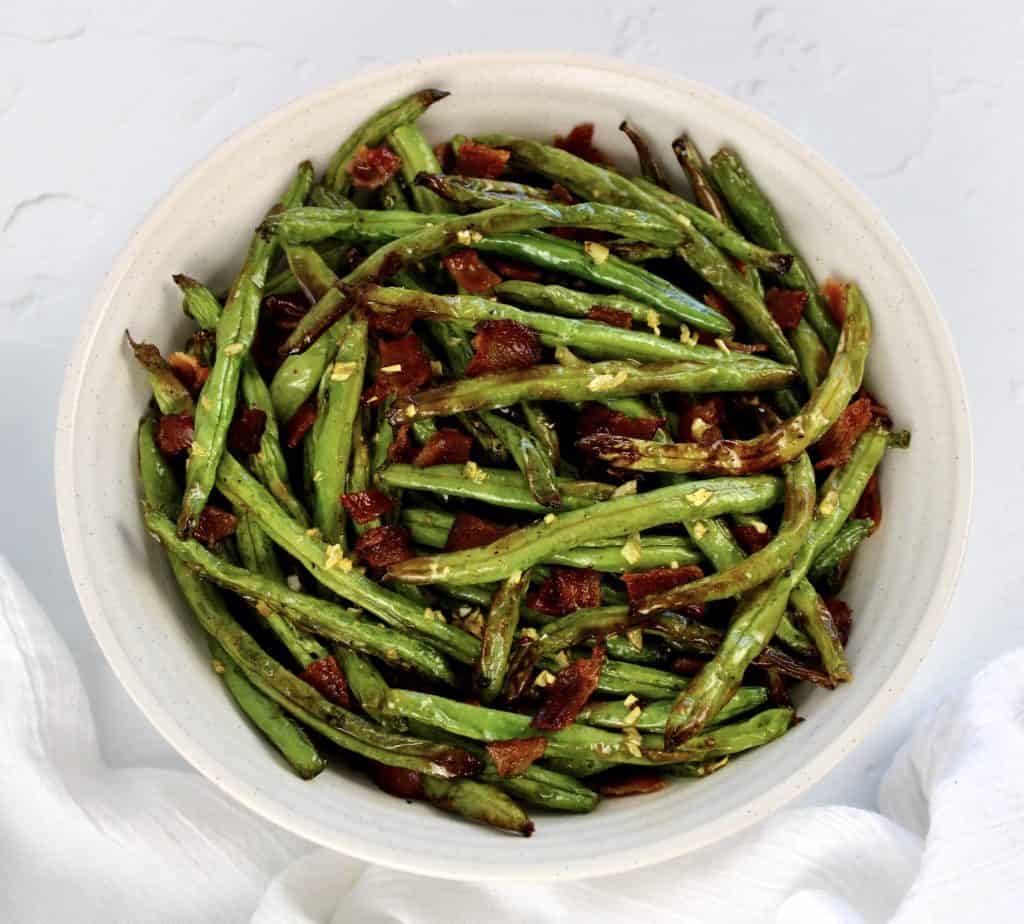 overhead view of roasted green beans in white bowl