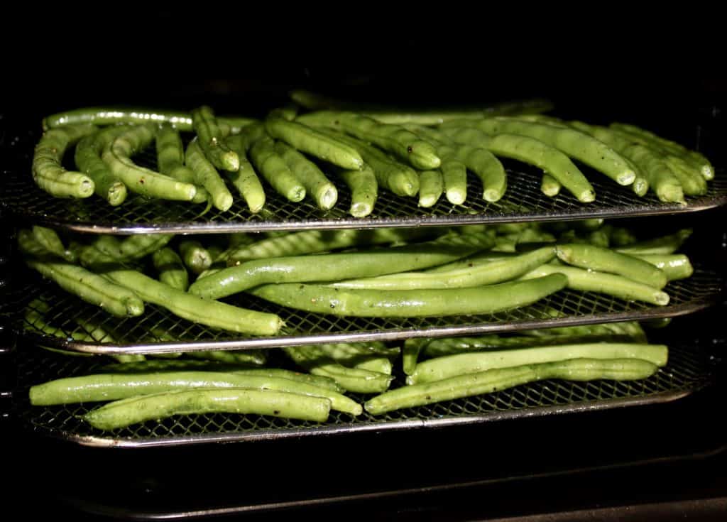 green beans roasting on 3 racks in air fryer