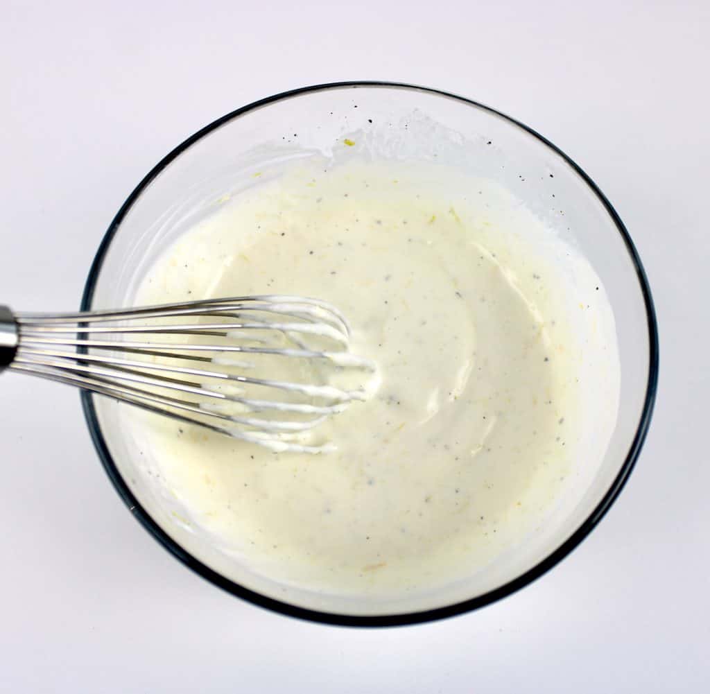 Creamy Cucumber Salad dressing in glass bowl with whisk
