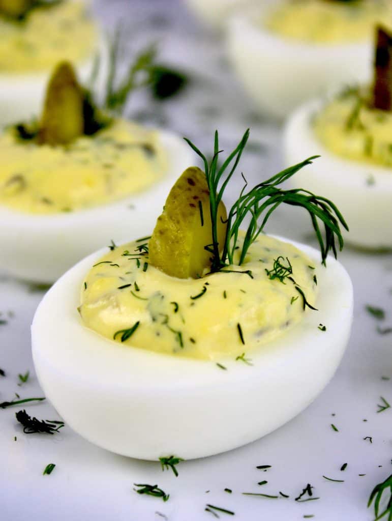Dill Pickle Deviled Eggs closeup with fresh dill and pickle slice on top
