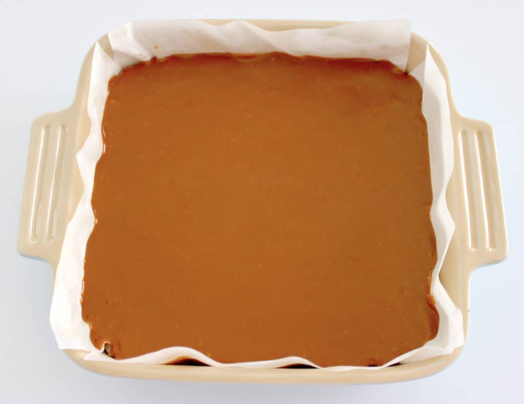 caramel layer of caramel slice bars in ceramic baking dish