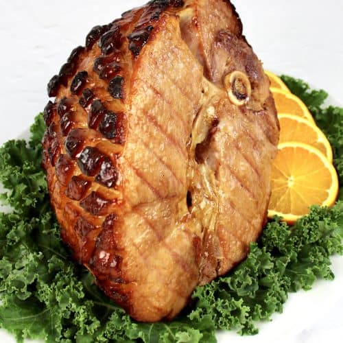 Keto Glazed Ham on platter with kale and sliced orange