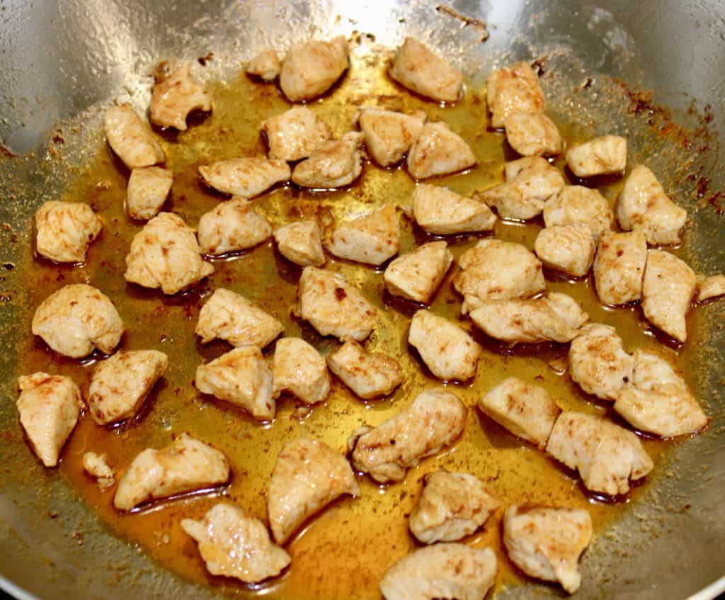 chunks of chicken frying in pan