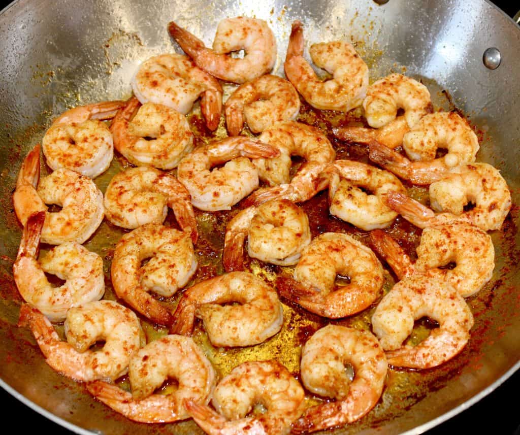shrimp frying in skillet with paprika on top