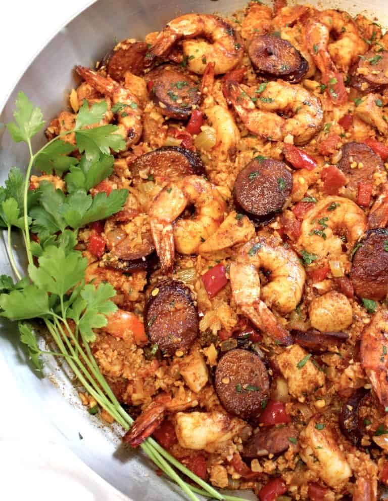 Keto Jambalaya in silver skillet with parsley sprigs on left side in pan