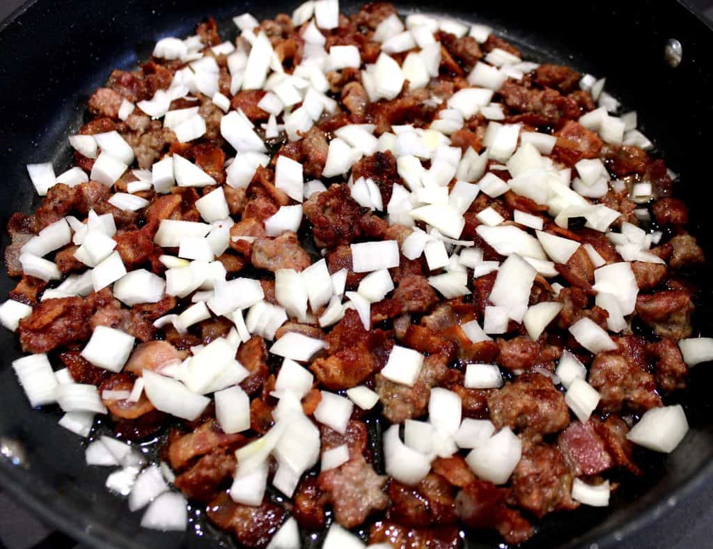 cooked bacon and sausage with chopped onion in skillet
