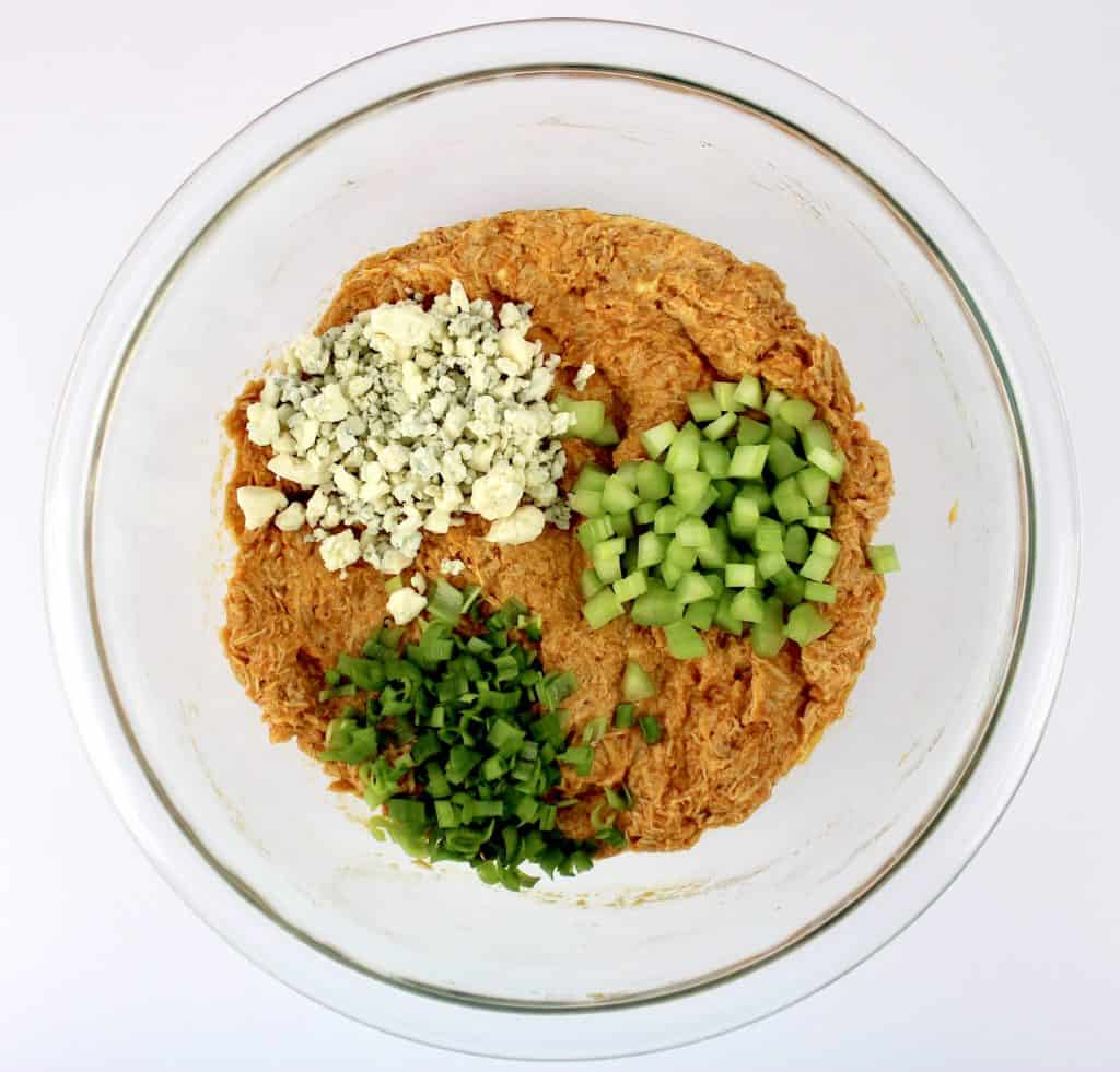 buffalo chicken chopped celery green onions and blue cheese crumbles in glass bowl