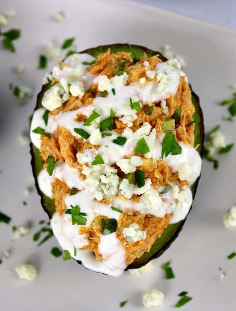 overhead view of Buffalo Chicken Stuffed Avocado with blue cheese drizzled on top