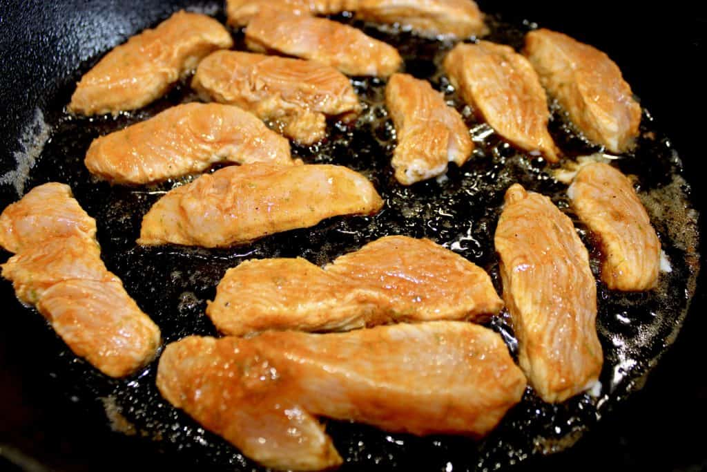 raw chicken fajita strips in skillet