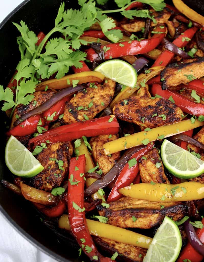 closeup of Chicken Fajitas in skillet with lime slices