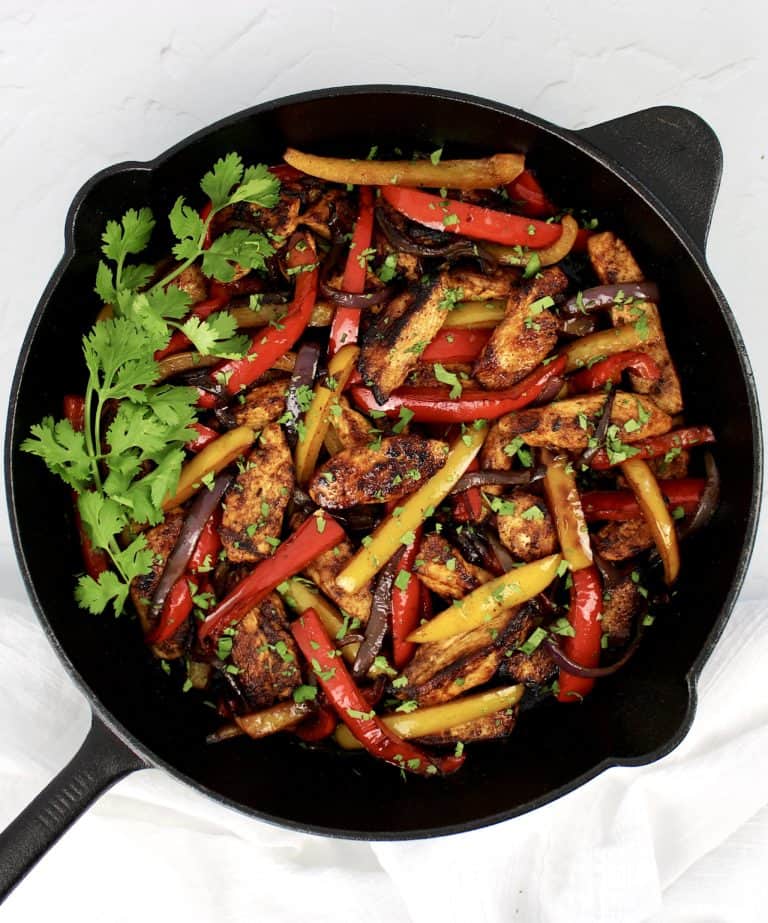 Chicken Fajitas in skillet with cilantro garnish