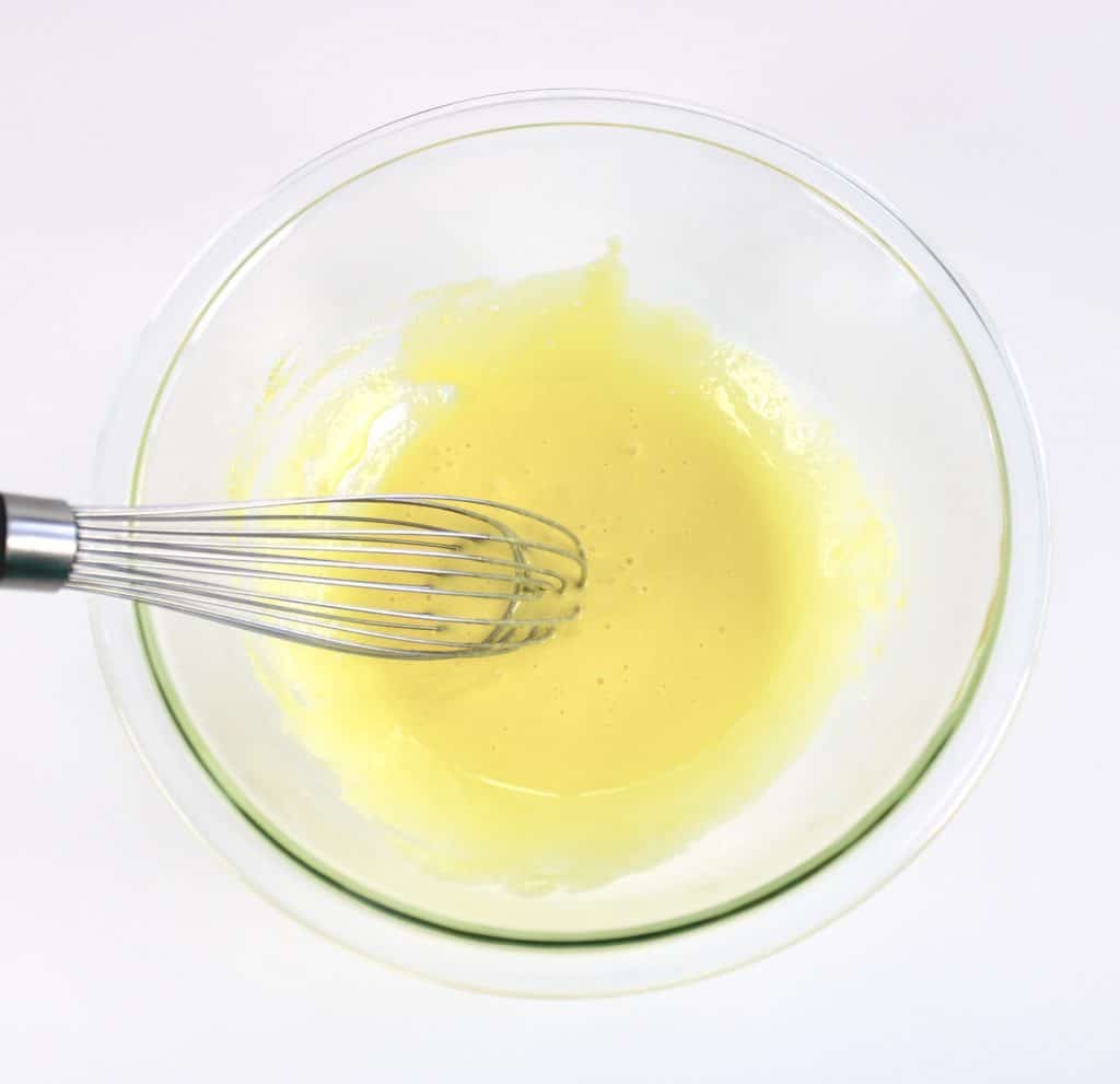 egg yolks and sugar whisked together with whisk in glass bowl