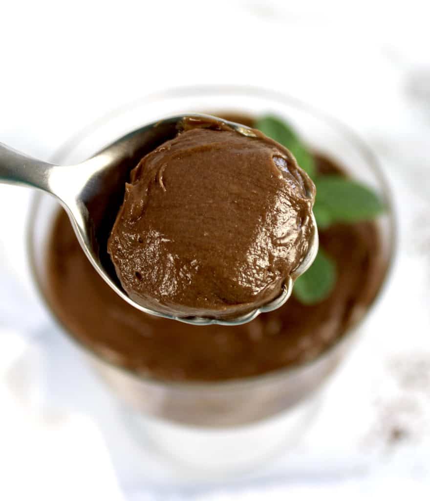 chocolate pudding in spoon held up over glass dish