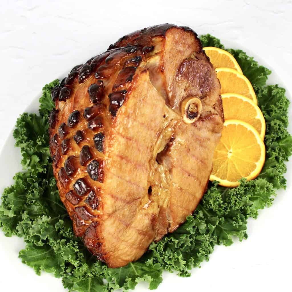 Keto Glazed Ham on platter with kale and sliced oranges