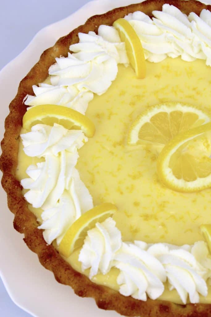 overhead view of Keto Lemon Mascarpone Tart with lemon slices and whip cream