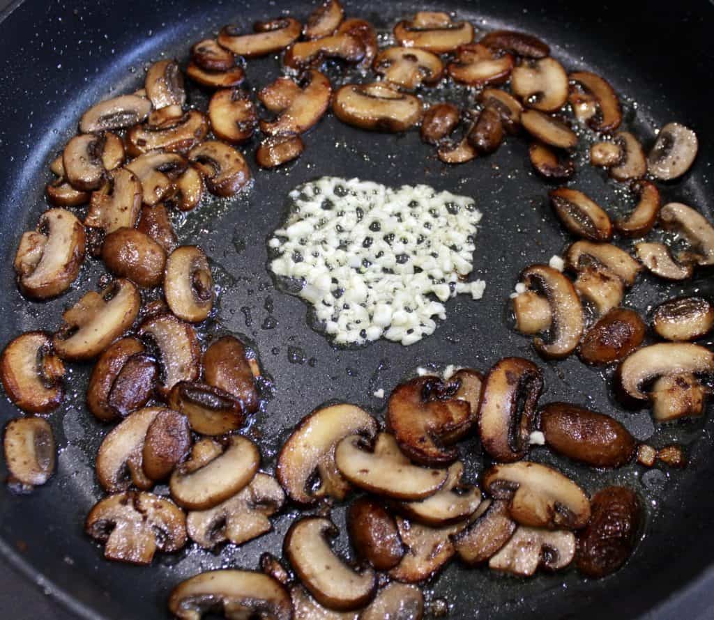 mushrooms and garlic cooking in skillet