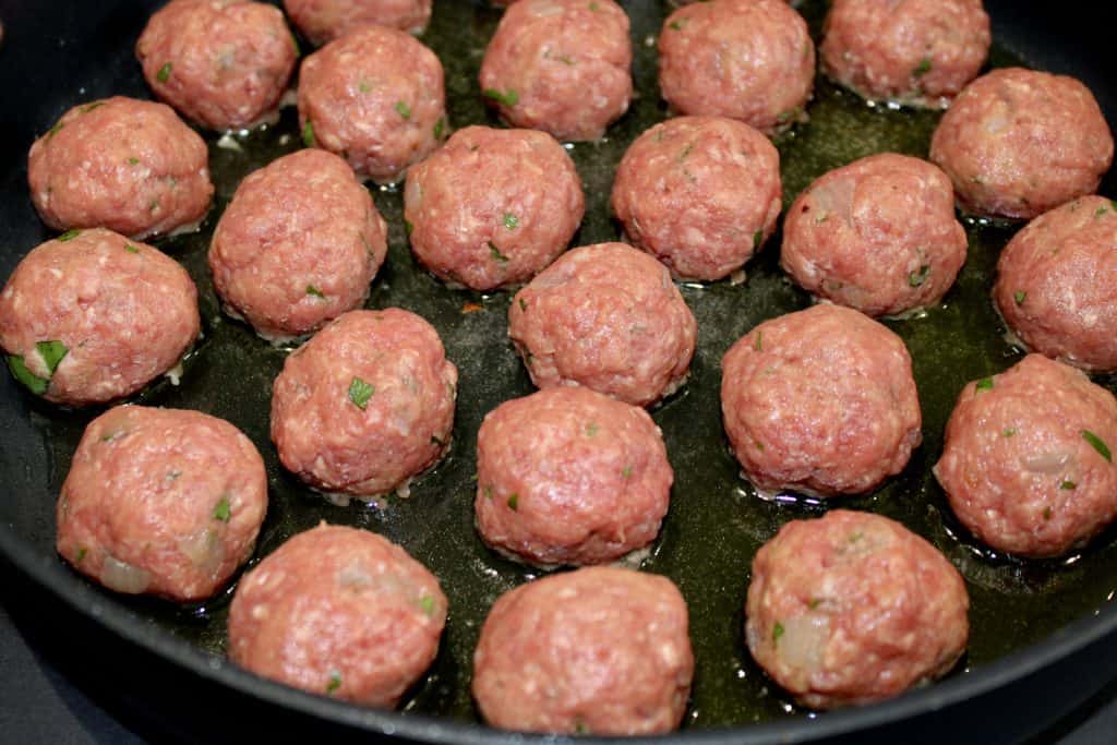 raw Salisbury Steak Meatballs frying in skillet
