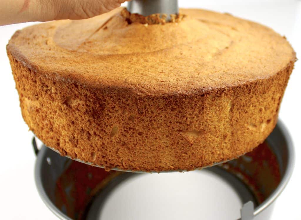 angel food cake being lifted out of tube pan