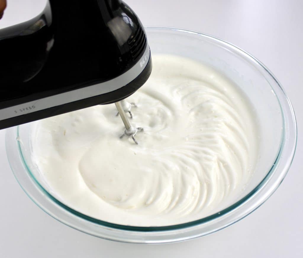egg whites being whipped to soft peaks with hand mixer