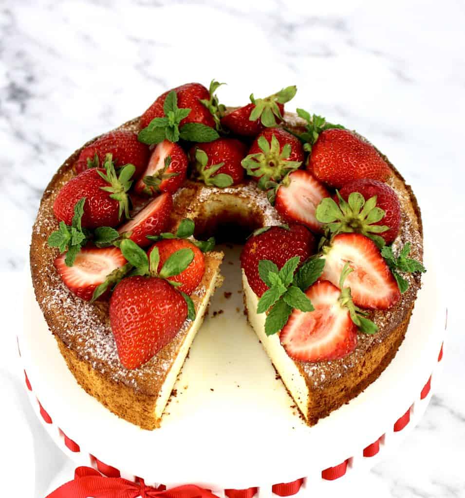 angel food cake with strawberries on top and slice missing