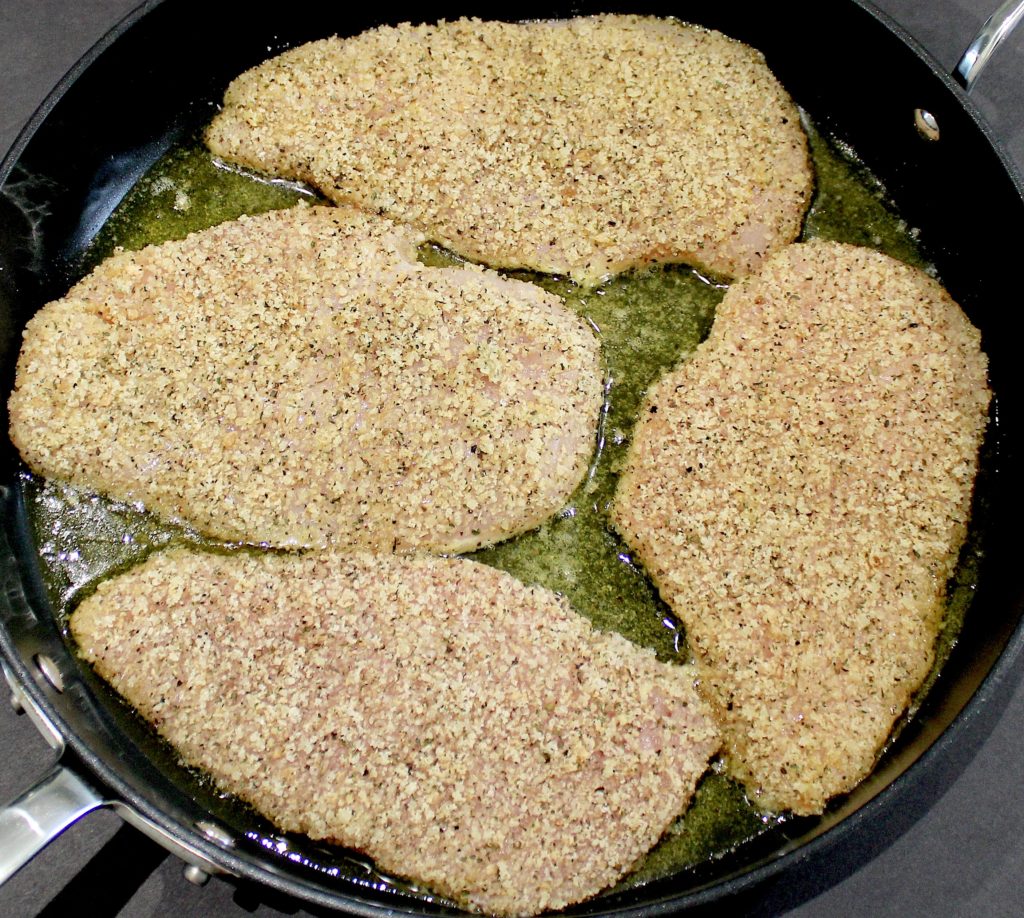 breaded chicken breasts frying in skillet