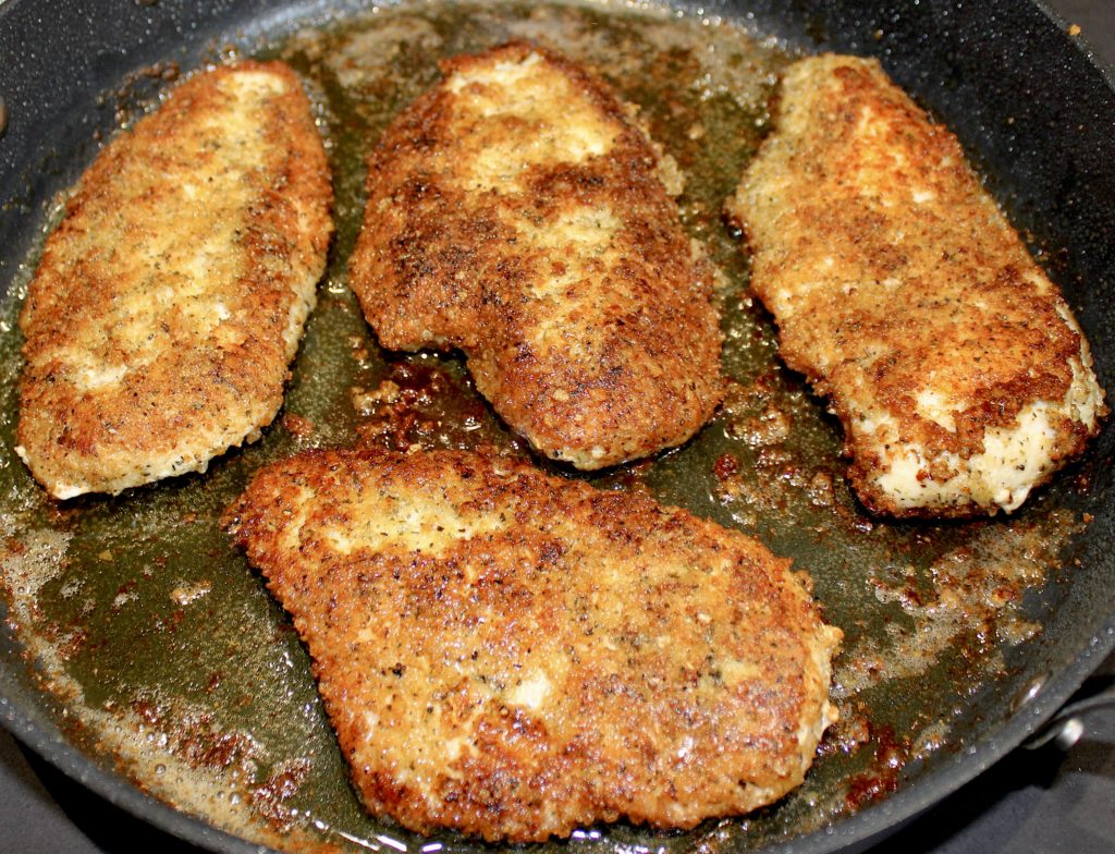 fried chicken breasts in skillet with olive oil
