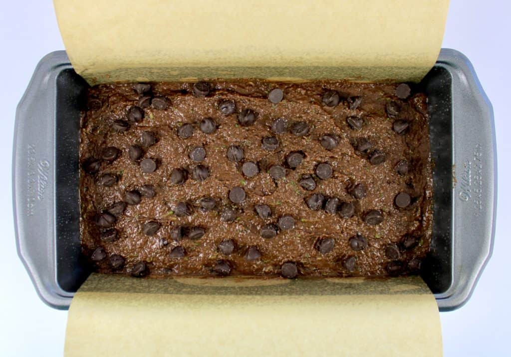 chocolate zucchini bread batter in loaf pan with chocolate chips on top
