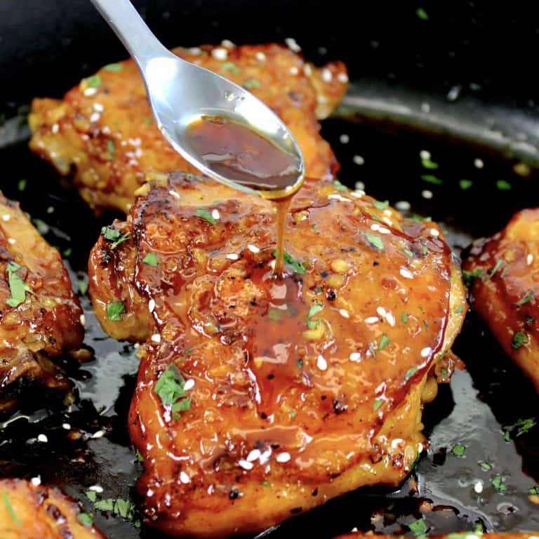 honey garlic chicken with sauce being spooned over top