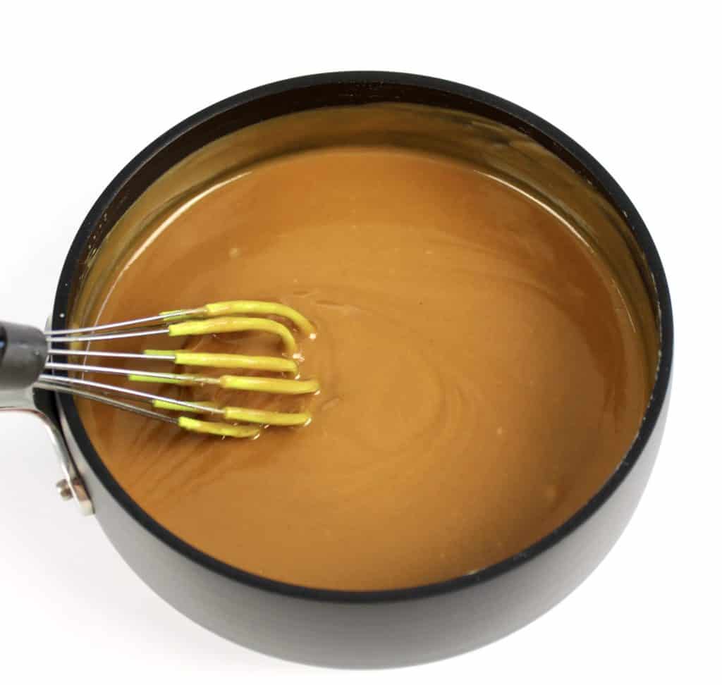 peanut butter fudge batter in saucepan with whisk