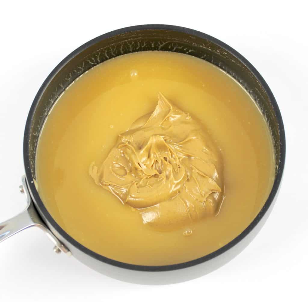 sweetened condensed milk in saucepan with peanut butter in center