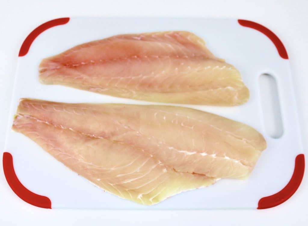 2 large filets of red snapper on white cutting board