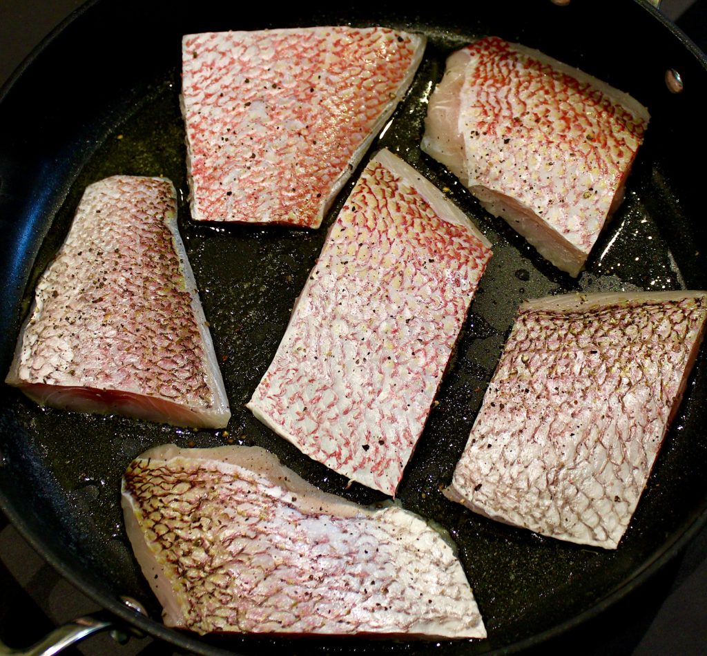 6 pieces of red snapper in skillet skin side up