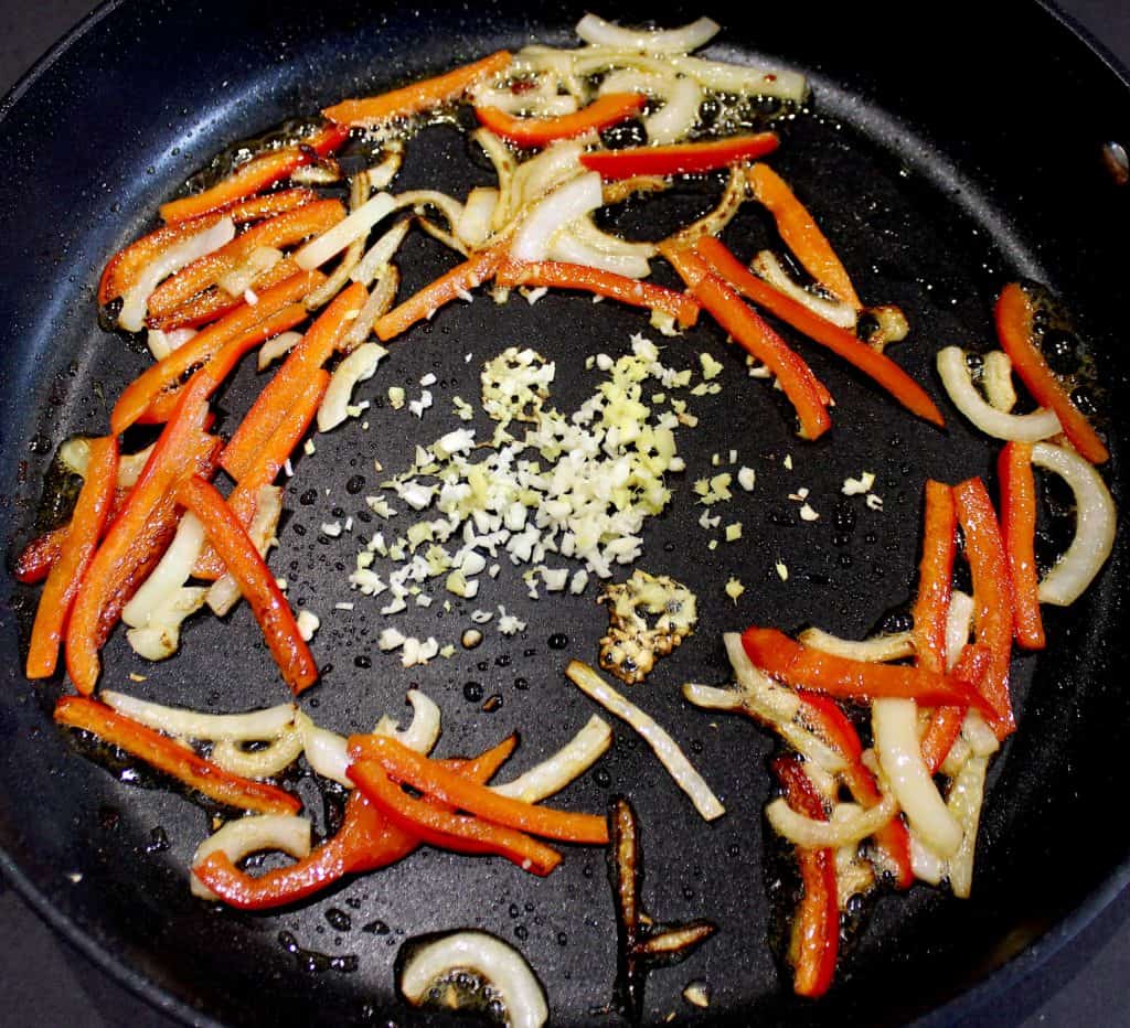 red bell pepper onion garlic and ginger in skillet